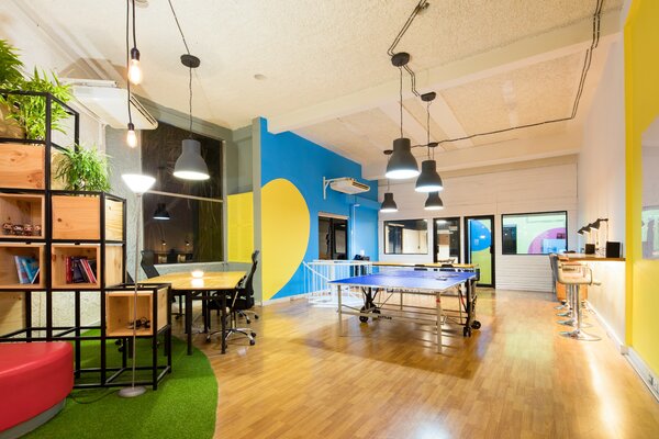 Espace de travail moderne et coloré avec tables et assises facilement déplaçables et des espaces de détente