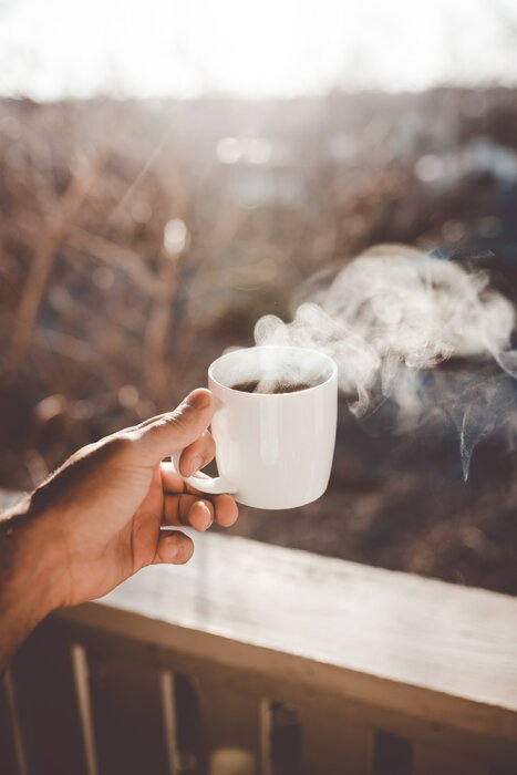 Main tenant une tasse de café chaud